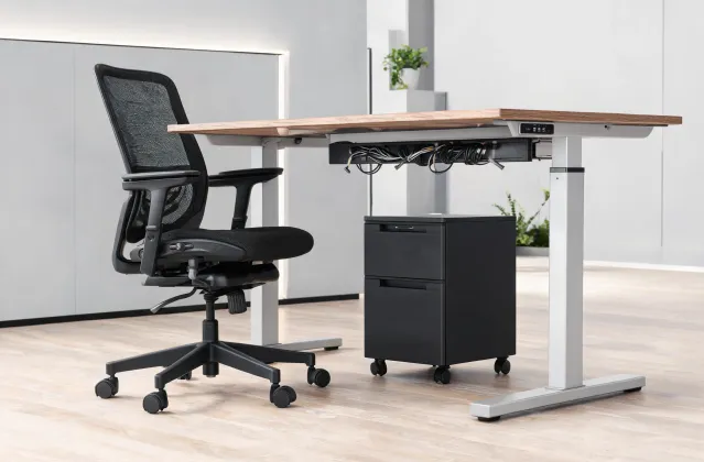 Ergonomic task chair beside a height adjustable desk
